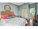 Bedroom with a woven headboard, light blue walls, and wood flooring at 2363 Hanover Dr, Dunedin, FL 34698