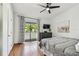 Bedroom featuring sliding glass door, dark dresser, ceiling fan and hardwood floors at 2363 Hanover Dr, Dunedin, FL 34698
