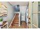 Foyer view showcasing the wooden staircase and decorative artwork, illuminated by natural light at 2363 Hanover Dr, Dunedin, FL 34698