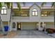 Charming exterior view of a residence showcasing its attached garage, stucco facade and tropical landscaping at 2363 Hanover Dr, Dunedin, FL 34698