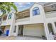 Townhouse with arched windows, private garage, and a quaint entryway with tasteful landscaping at 2363 Hanover Dr, Dunedin, FL 34698