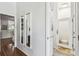 Hallway featuring sleek mirrors, hardwood floors, and entry to the bathroom and other rooms at 2363 Hanover Dr, Dunedin, FL 34698