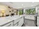 Well-equipped kitchen with stone counters, stainless appliances, and a breakfast bar overlooking a cozy living area at 2363 Hanover Dr, Dunedin, FL 34698