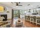 Open-concept living area with fireplace, hardwood floors, bar stool seating, and seamless flow to the kitchen at 2363 Hanover Dr, Dunedin, FL 34698