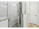 Bathroom with modern shower boasting mosaic tile accents, a seamless glass door, and tiled flooring at 2363 Hanover Dr, Dunedin, FL 34698