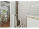 Stylish shower featuring white and mosaic tiling, a shower seat, and seamless glass door to the bathroom at 2363 Hanover Dr, Dunedin, FL 34698