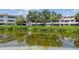 A beautiful waterfront view of condos surrounded by lush greenery at 2363 Hanover Dr, Dunedin, FL 34698