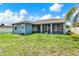 A view of the backyard shows a screened in patio and the side of the blue home at 23917 Pow Wow Dr, Lutz, FL 33559