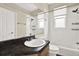 Well-lit bathroom features a single sink vanity with dark countertop and a shower-tub combination at 23917 Pow Wow Dr, Lutz, FL 33559