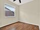 This bedroom is well-lit with wood floors, baseboards, and a single window with blinds at 23917 Pow Wow Dr, Lutz, FL 33559