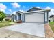 Exterior view of this single-Gathering home features a white garage door and blue paint at 23917 Pow Wow Dr, Lutz, FL 33559
