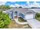 Exterior aerial view of a blue single Gathering home with large pillars and manicured landscaping at 23917 Pow Wow Dr, Lutz, FL 33559