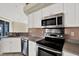 Modern kitchen with stainless steel appliances, white cabinets, and updated countertops at 23917 Pow Wow Dr, Lutz, FL 33559