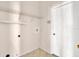 Laundry room with tiled floors, shelving, hookups and a white entry door at 23917 Pow Wow Dr, Lutz, FL 33559