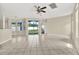Bright living room features tile flooring, fan, neutral paint, and sliding glass doors leading to the yard at 23917 Pow Wow Dr, Lutz, FL 33559