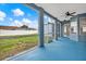 An outdoor covered patio with blue floors, a ceiling fan, and views of the yard at 23917 Pow Wow Dr, Lutz, FL 33559