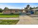 Street view of a single-story home with a turquoise door, solar panels, and landscaped yard at 2501 18Th S Ave, St Petersburg, FL 33712