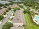 An aerial view showcases the community, lush greenery, and a nearby pool at 2628 Oleander Lakes Dr, Brandon, FL 33511