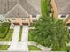 Aerial view of a townhome with a driveway, sidewalk, green landscaping, and an expansive tree at 2628 Oleander Lakes Dr, Brandon, FL 33511