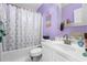 Purple bathroom featuring a shower/tub combination, toilet, and vanity at 2628 Oleander Lakes Dr, Brandon, FL 33511