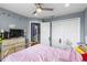 Cozy bedroom featuring a ceiling fan, double door closet, and view into the bathroom at 2628 Oleander Lakes Dr, Brandon, FL 33511