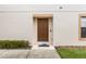 Exterior view of the front door with welcome mat, landscaping, and neutral paint at 2628 Oleander Lakes Dr, Brandon, FL 33511