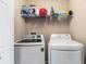 Bright laundry room featuring side by side washer and dryer, and storage shelving at 2628 Oleander Lakes Dr, Brandon, FL 33511