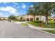 Street view of townhomes featuring attached garages, manicured lawns, and a well-maintained neighborhood in a sunny environment at 2628 Oleander Lakes Dr, Brandon, FL 33511