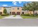 View of the facade of several townhomes with individual garages, landscaped yards, and street access at 2628 Oleander Lakes Dr, Brandon, FL 33511