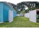 Fenced backyard featuring green grass, utility shed, and a white privacy fence at 2715 Bel Aire Cir, Tampa, FL 33614