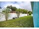 Backyard featuring a white privacy fence, green grass, and tropical plants at 2715 Bel Aire Cir, Tampa, FL 33614