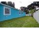 Backyard featuring green grass, storage shed, and a white privacy fence at 2715 Bel Aire Cir, Tampa, FL 33614