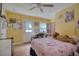 Bright bedroom features a ceiling fan, a sunny yellow wall color, and ample natural light at 2715 Bel Aire Cir, Tampa, FL 33614