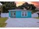 Turquoise house with white trim, brick driveway, and a well-maintained front yard at 2715 Bel Aire Cir, Tampa, FL 33614