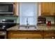 Stainless steel sink and faucet with granite countertops and matching brown cabinetry at 2715 Bel Aire Cir, Tampa, FL 33614