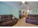 Inviting living room with wood-look tile flooring, ceiling fan and comfortable reclining sofa at 2715 Bel Aire Cir, Tampa, FL 33614
