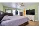 Bright main bedroom with wood-look tile flooring, ceiling fan, and ensuite bathroom at 2715 Bel Aire Cir, Tampa, FL 33614