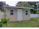 Utility shed featuring two windows, a white entry door, and green grass at 2715 Bel Aire Cir, Tampa, FL 33614