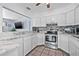 Bright kitchen features white cabinets, mosaic backsplash, and stainless steel appliances at 2861 Pinellas Point S Dr, St Petersburg, FL 33712