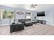 Bright living room with tile flooring, a ceiling fan, large windows, and a modern leather sectional at 2861 Pinellas Point S Dr, St Petersburg, FL 33712