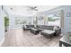 Bright living room features tile flooring, large windows, a ceiling fan, and a modern leather sectional at 2861 Pinellas Point S Dr, St Petersburg, FL 33712