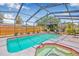 Relaxing screened-in pool area includes a heated pool, hot tub, patio furniture, and lush landscaping at 2861 Pinellas Point S Dr, St Petersburg, FL 33712