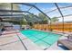 Screened-in pool with a jacuzzi, outdoor furniture, and a surrounding fenced-in yard at 2861 Pinellas Point S Dr, St Petersburg, FL 33712