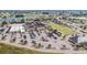 Aerial view of community amenities with lawn bowling, clubhouse, manicured landscaping, and ample parking in Sun City Center at 304 Caloosa Palms Ct, Sun City Center, FL 33573