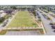 This view of the amenities showcases lawn bowling, clubhouse, manicured landscape, and parking in Sun City Center at 304 Caloosa Palms Ct, Sun City Center, FL 33573