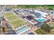 Wide aerial view of a large community center with lawn bowling, pool, and ample parking at 304 Caloosa Palms Ct, Sun City Center, FL 33573