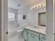 Bright bathroom features a shower-tub combo, white tiling, and a vanity with a light-green cabinet at 304 Caloosa Palms Ct, Sun City Center, FL 33573