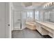 Relaxing bathroom with corner tub, glass shower, dual sinks, and plantation shutters at 304 Caloosa Palms Ct, Sun City Center, FL 33573