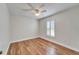 This bedroom has wood-look floors, a ceiling fan, and a shuttered window at 304 Caloosa Palms Ct, Sun City Center, FL 33573