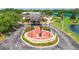 Aerial view of a community center entrance with landscaping and a veterans memorial at 304 Caloosa Palms Ct, Sun City Center, FL 33573